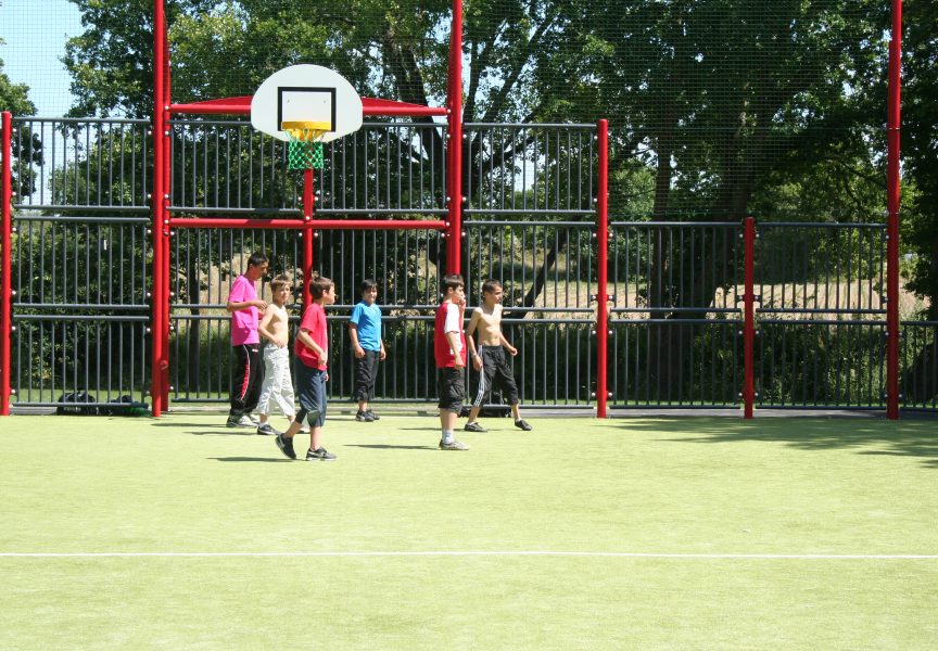 Des enfants jouent sur le terrain multisports.