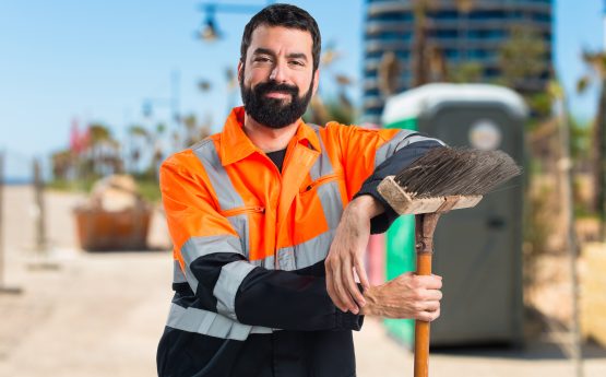 Un homme des services techniques avec un balai.